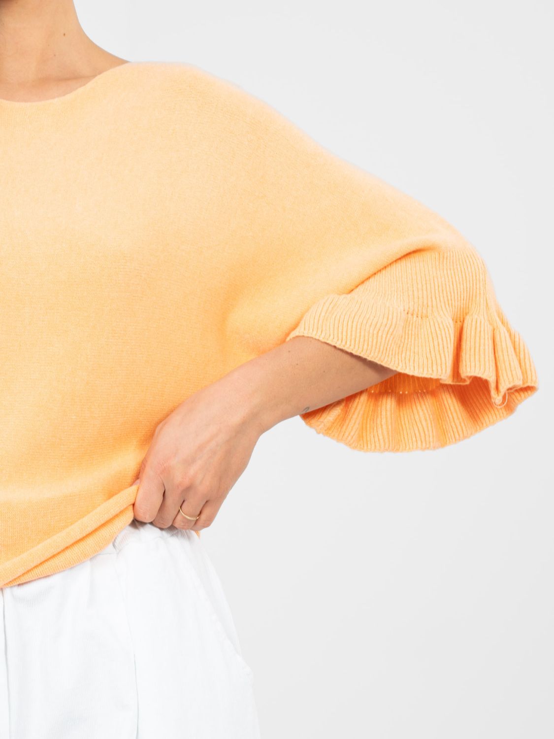 Elegancki pomarańczowy sweter z falbaną i rękawem 3/4